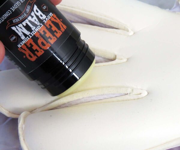 Applying KEEPER BALM to a goalkeeper glove palm